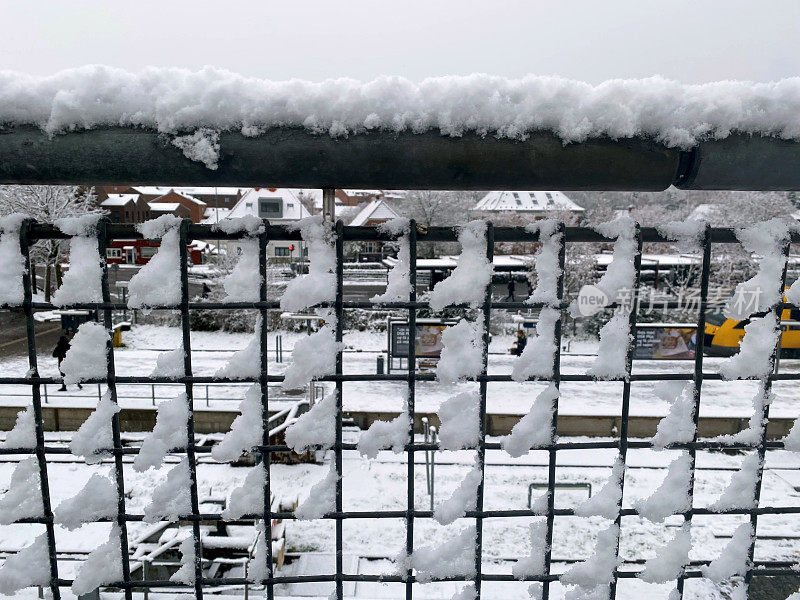 火车站被雪覆盖的金属栅栏