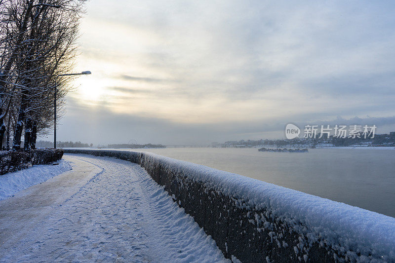 冬天的河堤。河上的黎明。冬河在城中。在一个阳光明媚的大雪冬日，河边的城堤。