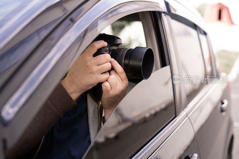 私家侦探或调查员或狗仔队坐在车里在街上拍照