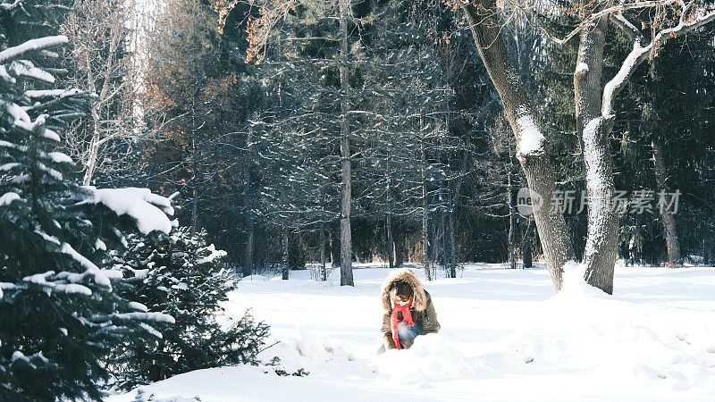 兴高采烈的女游客在冬季公园玩雪