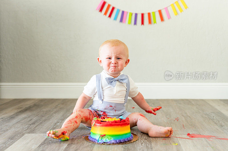 一个小男孩一岁的生日蛋糕，他觉得恶心，非常不确定，有趣的可爱的孩子