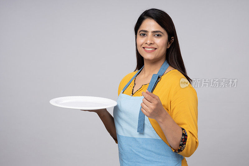 微笑的女厨师拿着空盘子的股票照片