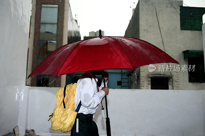 雨季，小学生在家里拿伞的照片