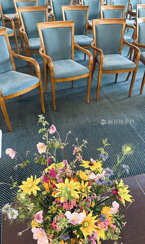 从演讲者的角度看讲堂里的椅子，前景中有一束鲜花