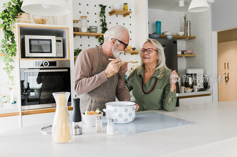 老夫妇在厨房一起做饭。退休后的生活方式，休闲和在家消磨时间。