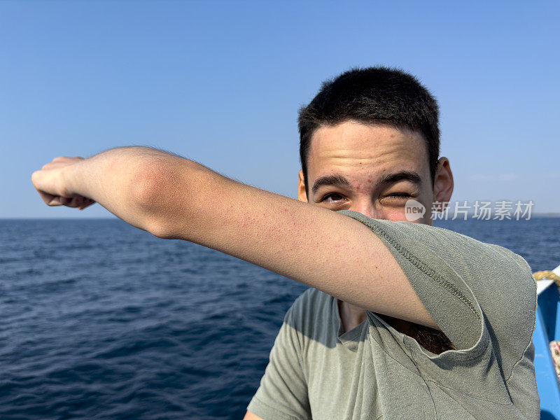 这个男孩正在北爱琴海的一艘男孩游船上旅行。体贴又快乐。晴朗的夏日。旅游的背景。旅游的概念。