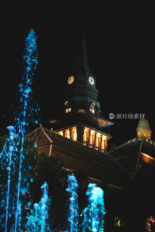 屋顶上的时钟和喷泉在晚上