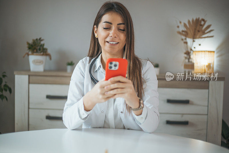一个可爱的女医生在她的智能手机上打字