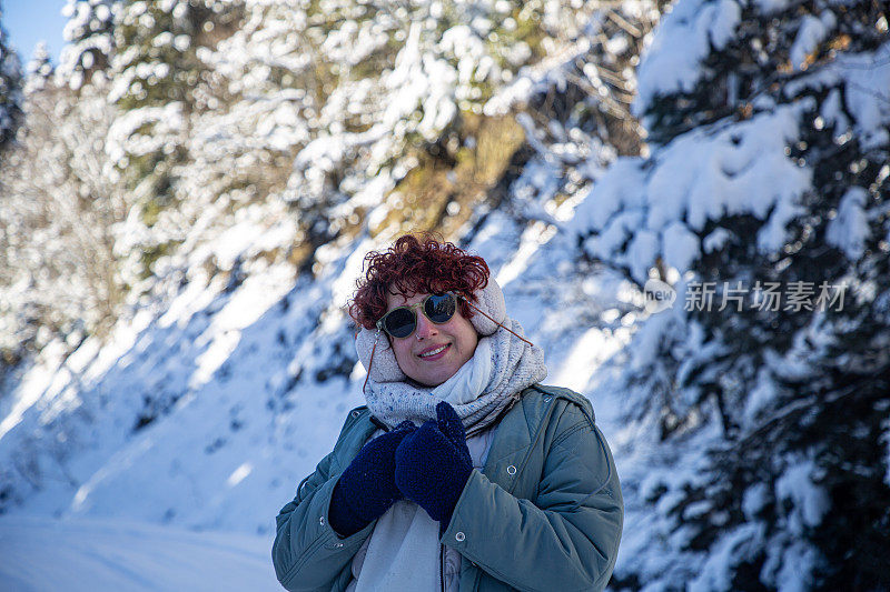 美丽的女人和冬天被雪覆盖的树