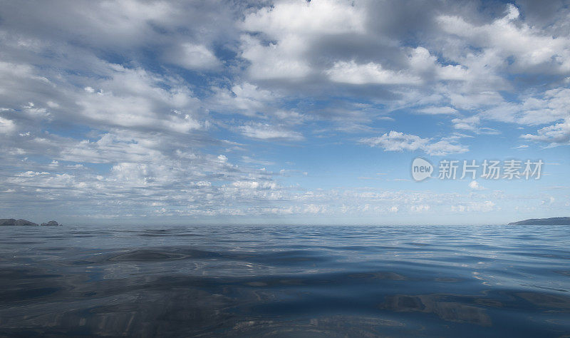 背景白云和他们的反射在开阔的大海，与文字的空间