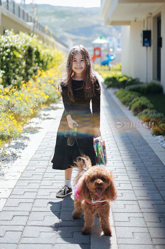 一个可爱的小女孩在外面散步，和她的狗狗亲密无间