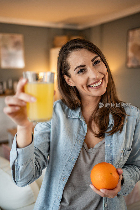 一位年轻女子享受着喝鲜橙汁的时刻