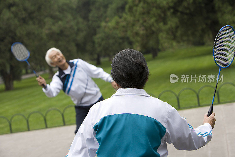 老年夫妇在公园打羽毛球