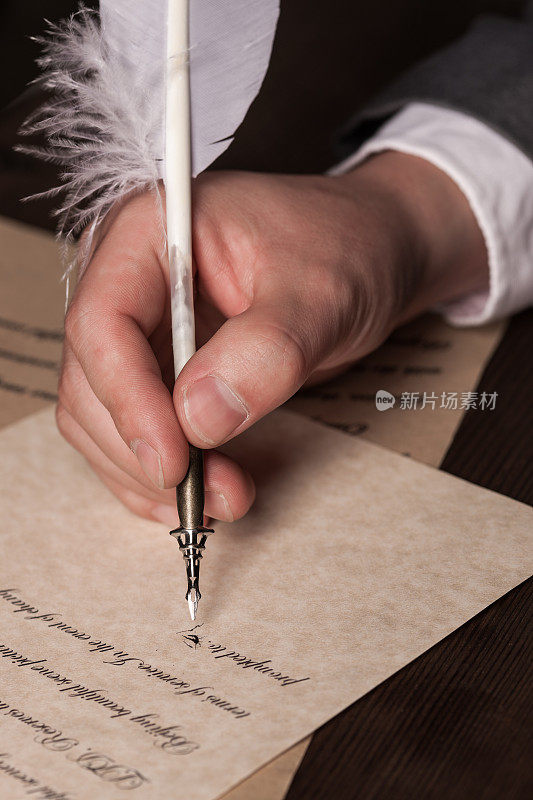 男人的手拿着鹅毛笔准备写字
