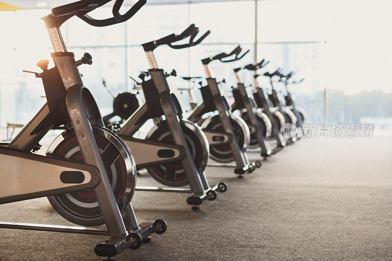 现代化的健身房内部配备健身器材，健身自行车