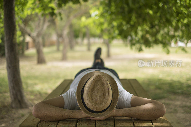 安静的男孩戴着帽子躺在公园里