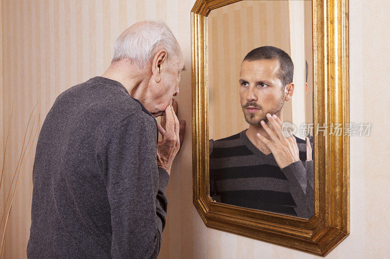 年长的人看着镜子里年轻的自己