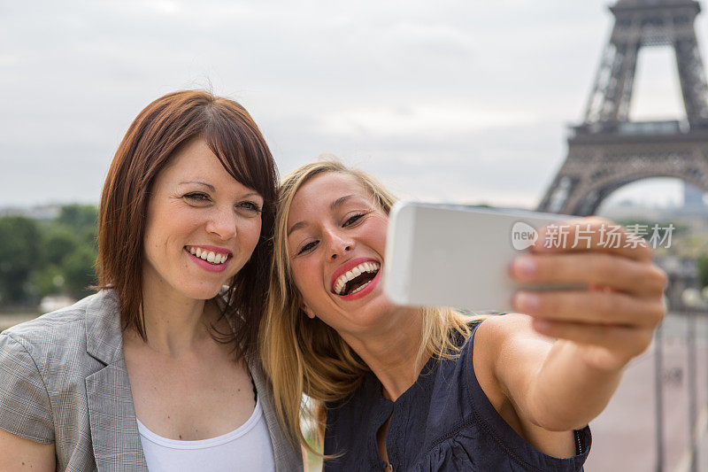 巴黎的两个女孩用手机自拍――埃菲尔铁塔