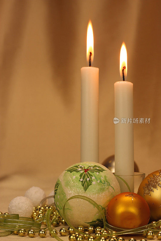 长长的圣诞蜡烛和带有金色缎子背景的装饰物
