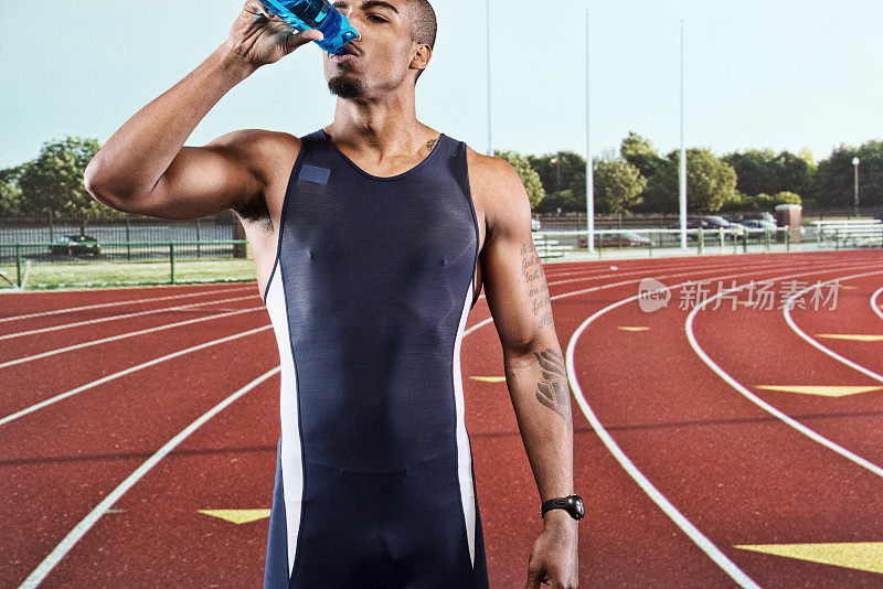 男跑步者在田径赛事中饮用水