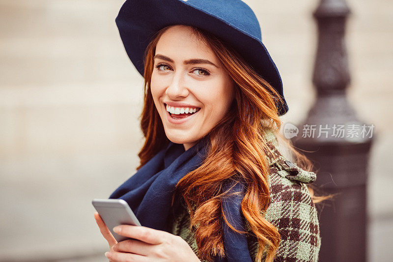 幸福的女人在街上发短信