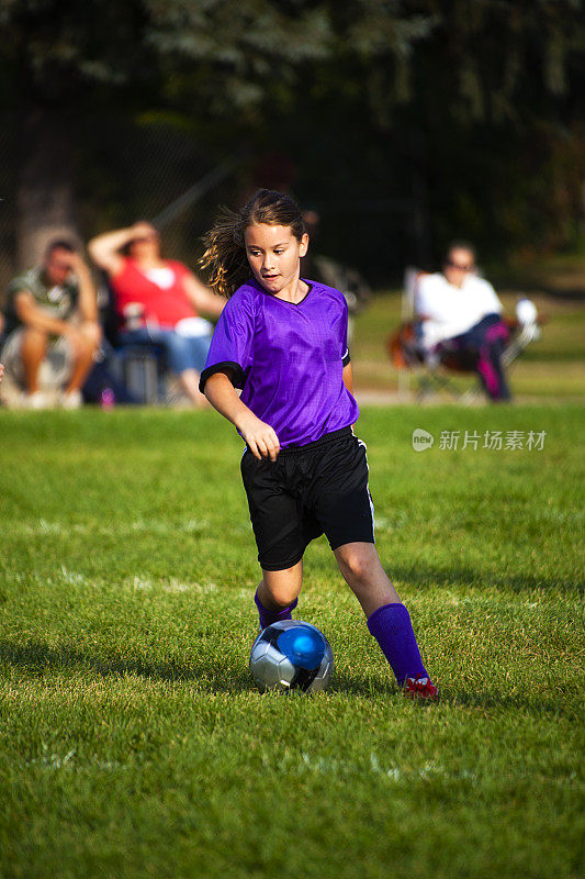 儿童足球运动员运球在金色的阳光和copyspace