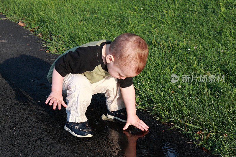 小男孩在水坑里玩耍
