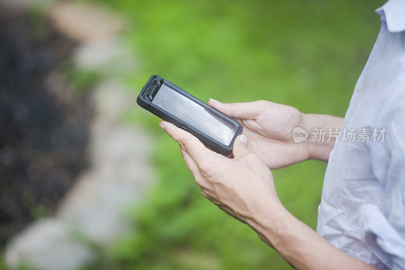 一个男人在外面用他的触摸屏手机