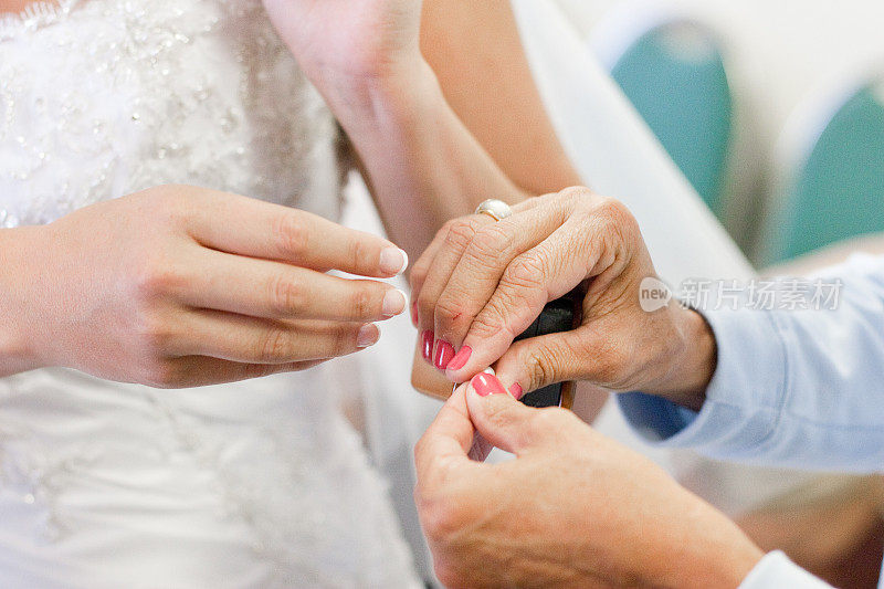 新娘的手接受来自年长女人的戒指