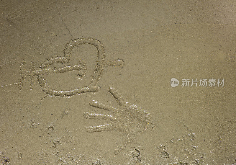 手印和心形画在湿水泥。