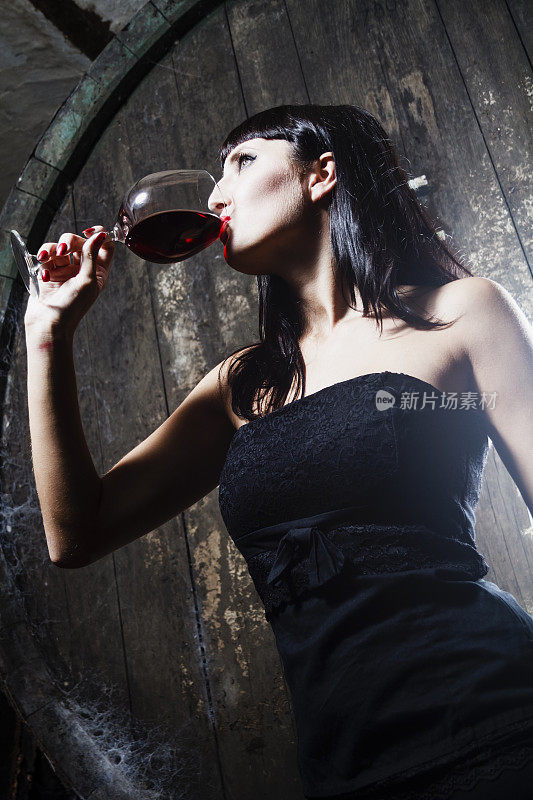 年轻女子靠墙喝酒