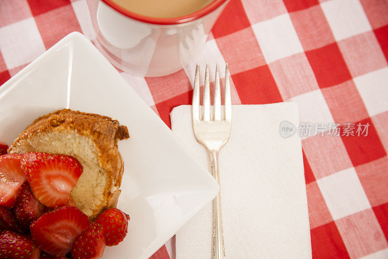 用叉子盛着新鲜草莓和咖啡。甜点。