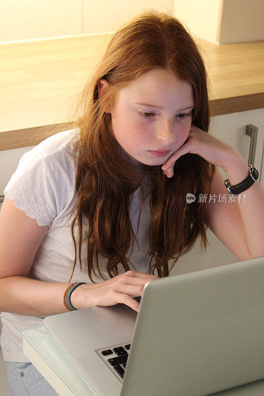 女孩在厨房用笔记本电脑做作业，学习