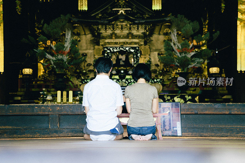 日本夫妇在佛教寺庙祈祷，后视图