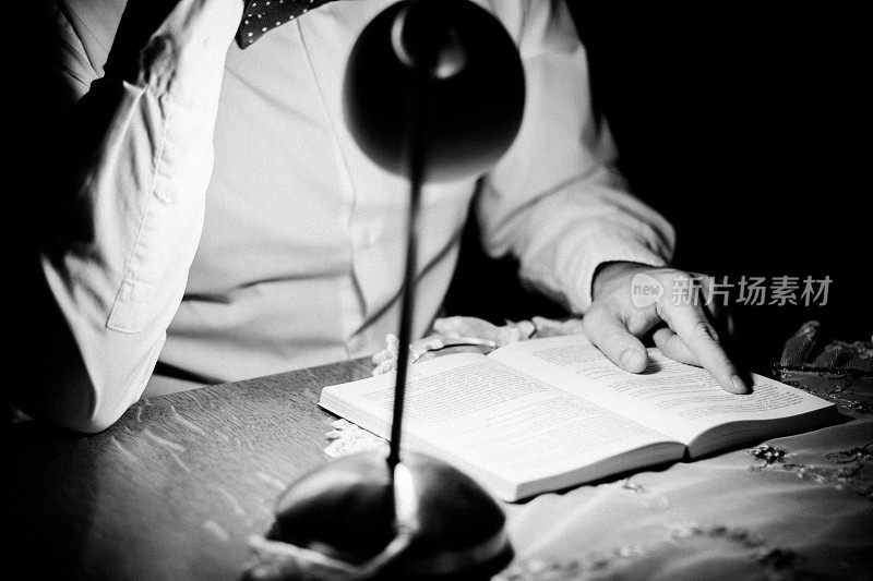 一个男人晚上在书桌前学习的特写