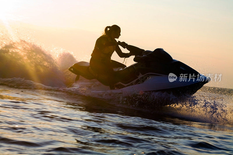 夕阳西下，美丽的女孩骑着摩托艇