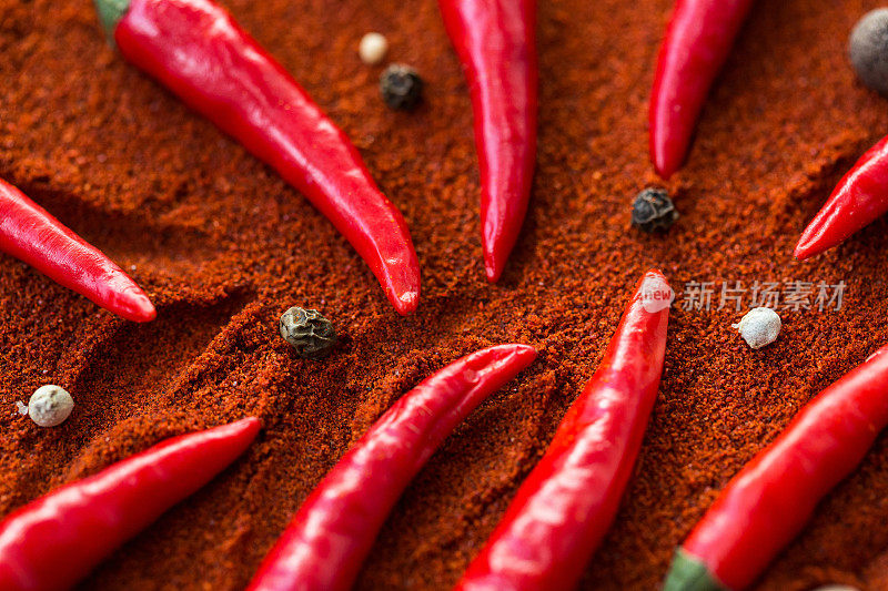 红辣椒，流行的香料概念-特写设计精美的红辣椒在棕色的背景下，与圆形的黑种子和白辣椒