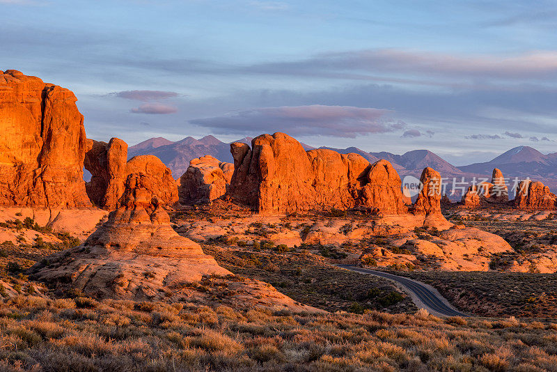 犹他州日落-红石构成在拱门国家公园，犹他州。背景中的拉萨尔山脉。