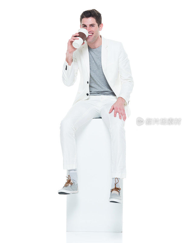 白衣帅哥坐在盒子上拿着咖啡杯