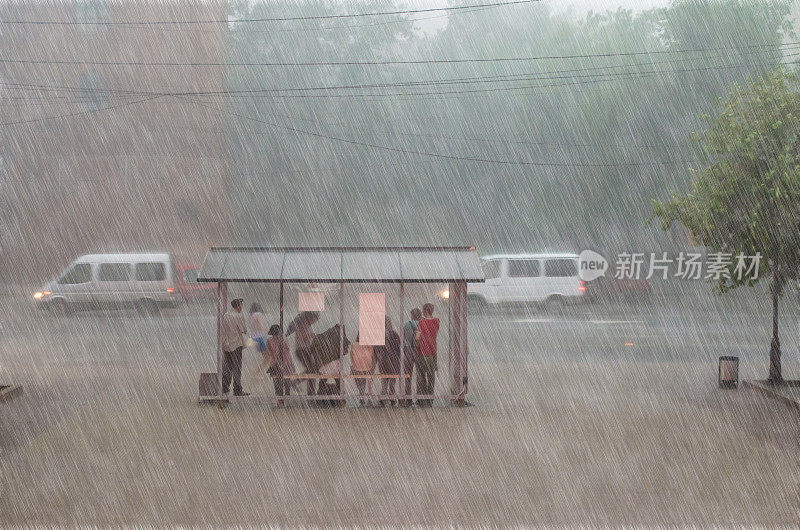 一群人在城市的一个车站躲避大雨。