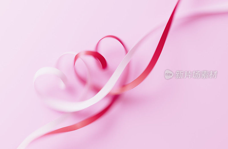 情人节卡片-心形丝带纠结在粉红色的背景