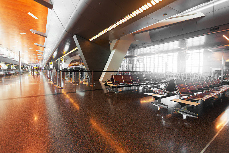 日落时分，现代化的机场航站楼配有黑色真皮座椅。