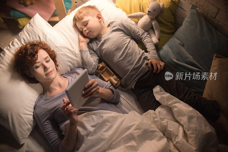 母亲和儿子在床上读故事