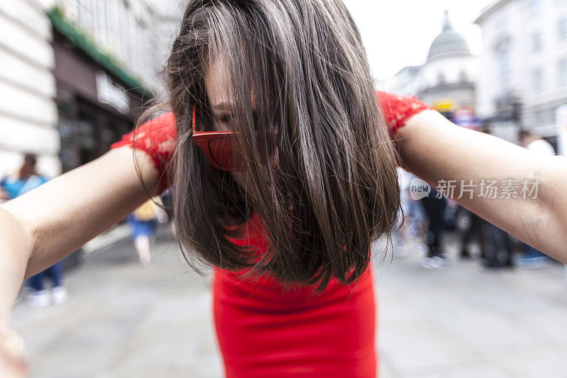 头发吹到脸上的女人，看着摄像机