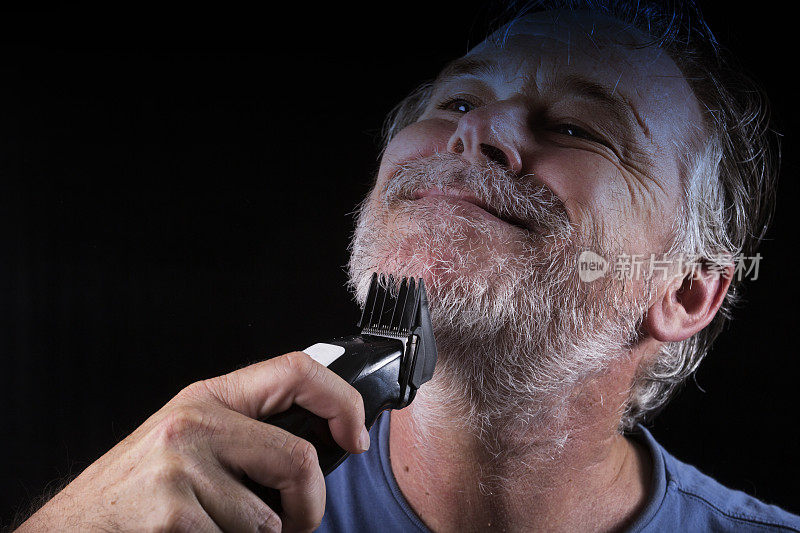 男人用电动剃须刀刮胡子