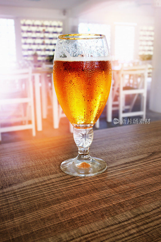 酒吧桌上放着一杯精酿啤酒，背景是精致的散焦