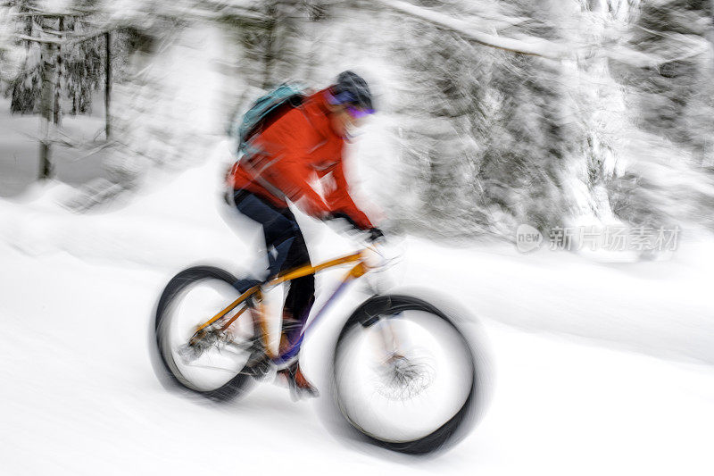 一张模糊的山地自行车手在雪道上骑行的照片