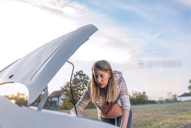 女人试图修理她的汽车故障后