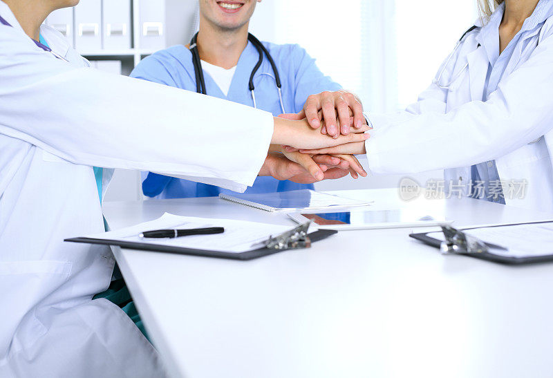 一群医生在会议上手拉手。团队合作和医学上的成功。