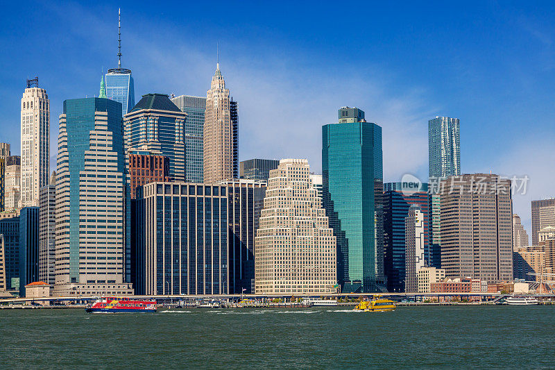纽约市天际线与金融区曼哈顿下东区和游船航行在东河，纽约，美国。